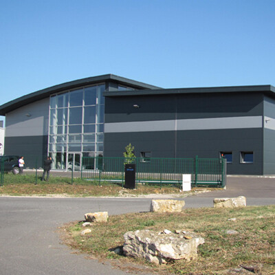 Grey industrial building with a curved roof for small and medium-sized enterprises. Buildings for SMEs companies